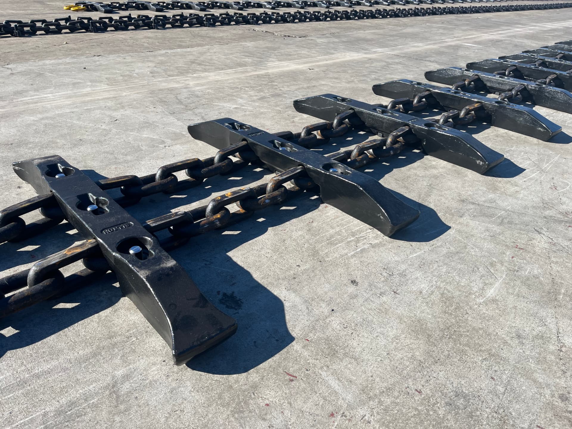 BSL flight bar assembly bolted across twin-strand chain, laid out on the yard concrete